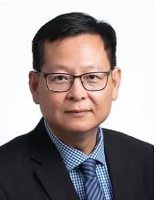 A professional Asian man wearing glasses and a suit, partnering with various organizations to provide pro bono services.